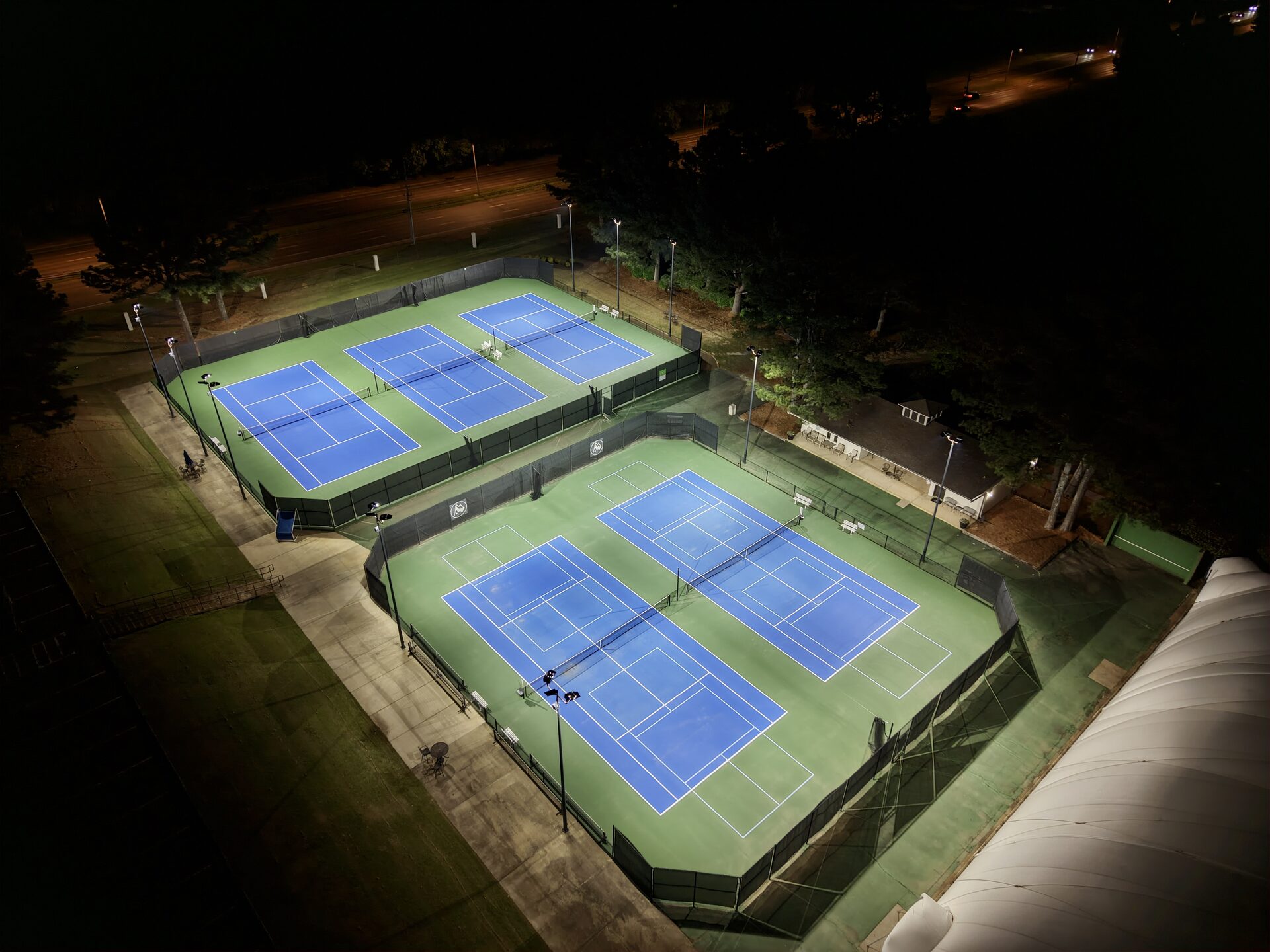 Aerial view of Windyke Country Club tennis courts and dome at night, fully illuminated by eneroi LED lighting system